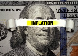 US $100 bill with the word ‘inflation’ written across Benjamin Franklin’s face
