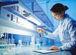 Pharmaceutical laboratory testing A pharmaceutical laboratory researcher holds a vial and records results of a test in a laboratory