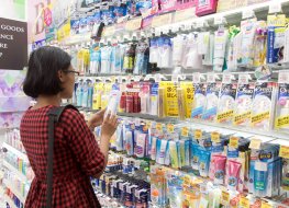 A young woman chooses cosmetics at a store in Osaka, Japan.