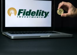 Bitcoin coin with the Fidelity logo on a laptop screen