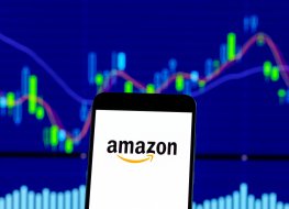Hong Kong, China - 28 December 2018: amazon logo is seen on an smartphone over stock chart
