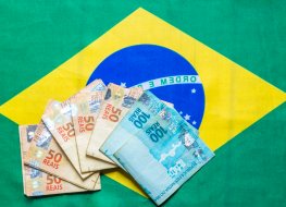 Brazilian currency on top of the national flag