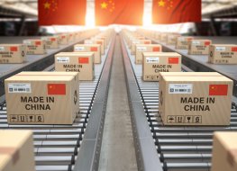 Cardboard boxes with Chinese-made text and a Chinese flag on a roller conveyor.