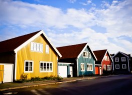 Picture of a swedish street with small multi coloured houses during spring. 