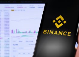 Binance logo on a smartphone in front of a computer screen