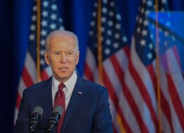 Joe Biden and flags of the United States of America in the background