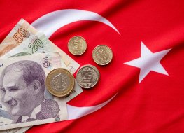 Turkish lira coins and notes on a Turkish flag