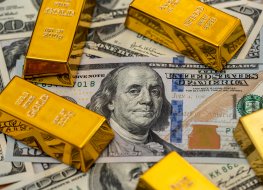 Several gold bars laid out on US dollar bills 