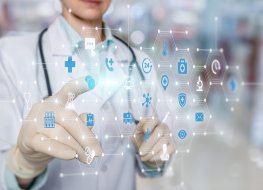 Doctor working on a virtual screen behind the structure of medical icons on a blurred background.