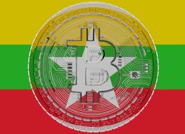 3D rendering of a large transparent bitcoin overlaid on the Flag of Myanmar