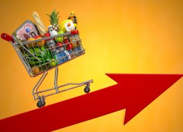 Grocery cart rolling on an upward red arrow, illustrating inflation