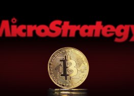 Bitcoin BTC representation coin with MicroStrategy logo in background.