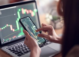 How to invest in cryptocurrency in India: A step-by-step guide. Closeup - Woman is checking Bitcoin price chart on digital exchange on smartphone, cryptocurrency future price action prediction.