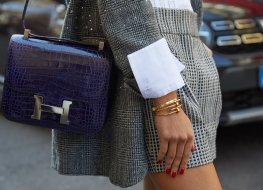 Woman with a blue leather Hermes bag and gold Cartier bracelet