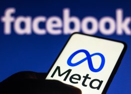 Meta logo on a mobile screen with a Facebook background