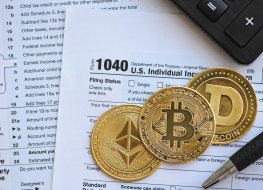 Tax return document with coins with crypto logos on it.