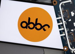 The abbc coin’s logo on smartphone next to a circuit board