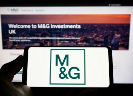 A image of Person holding smartphone with logo of British investment company M&G plc (MG) 