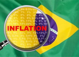 Magnifying glass focused on the word inflation on Brazil flag background
