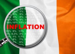 Magnifying glass focused on the word inflation on Ireland flag background