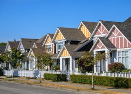  row of houses showing front yards of the houses and streets with trees and bushes in Richmond, British Columbia, Canada.