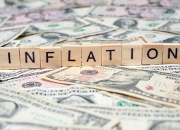 The word ‘inflation’ spelt out in Scrabble letters on top of US dollar notes 