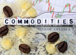 Coffee beans, rice, corn and a letter cube on the background of a dollar and a candle. The conceptual image of commodity trade.
