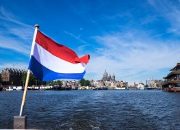 flag of the Netherlands on the background of the river in Amsterdam