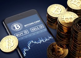 Bitcoin cash tokens next to a smartphone with trading bitcoin cash