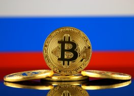 Coin with bitcoin (BTC) logo against flag with Russian background.