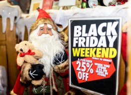 Santa Claus next to Black Friday sale sign in the UK