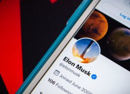 A photo of phone screen with displaying Elon Musk's Twitter profile.