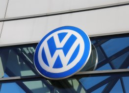 VW logo on white background VW logo hangs above the front of a showroom