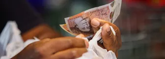 A customer handles cash at a market in the U.K.