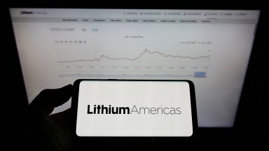 Person holding mobile phone with logo of Canadian company Lithium Americas Corp. on screen in front of business web page. Focus on phone display. Unmodified photo.