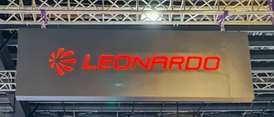 Logo dell'azienda Leonardo illuminato in rosso su un grande pannello display