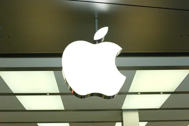 Apple logo illuminated on the exterior of a modern retail store