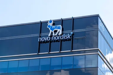 Novo Nordisk logo displayed on the glass façade of a modern office building, representing the global pharmaceutical and healthcare company.