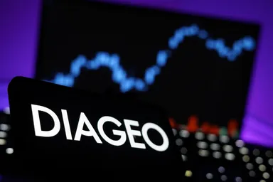 Diageo logo displayed in front of a blurred financial market chart, representing the global beverage company and its stock market performance. 