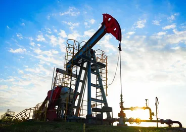 Pompa petrolifera in funzione al tramonto