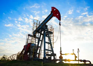 Oil pumpjack operating at sunset
