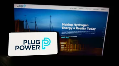 Plug Power logo displayed on a mobile device with the company’s website about hydrogen energy in the background