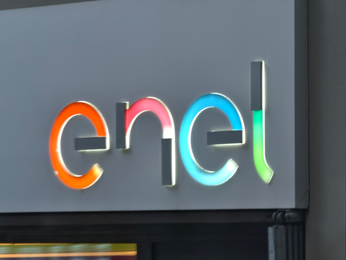 Enel logo displayed on the exterior of a company building with illuminated colorful lettering.