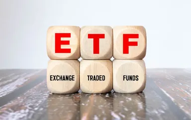 Wooden blocks displaying the acronym ETF and the words ‘Exchange Traded Funds’ on a wooden surface