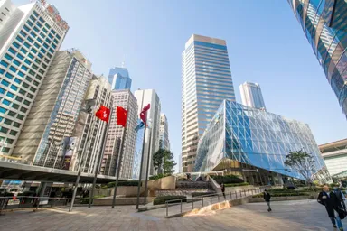 Skyline del distretto finanziario di Hong Kong con moderne torri per uffici e bandiere vicino a Exchange Square