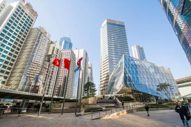 Hong Kong financial district skyline with modern office towers and flags near Exchange Square