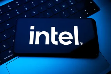 Intel-Logo auf einem Smartphone-Bildschirm, das auf einer Laptop-Tastatur liegt