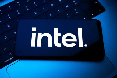 Intel logo displayed on a smartphone screen placed on a laptop keyboard