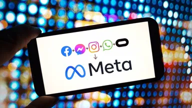 Smartphone displaying Meta logo with Facebook, Messenger, Instagram and WhatsApp icons on a colorful digital background