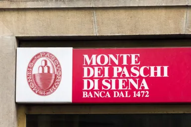 Monte dei Paschi di Siena bank logo displayed on a red sign on a building facade